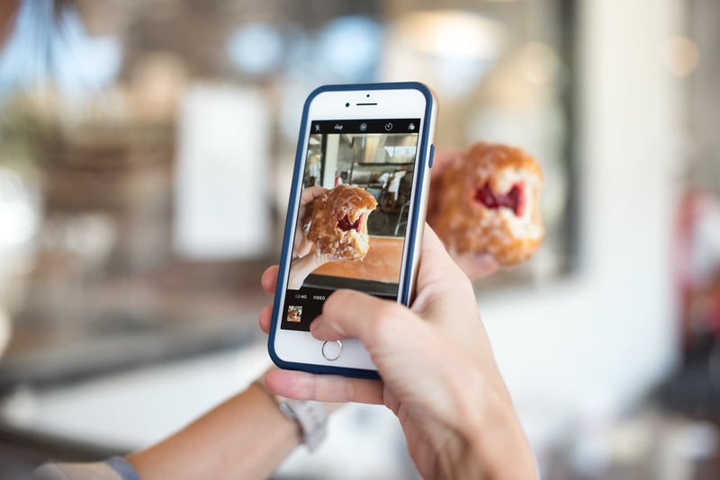 Person taking a photo of a pastry