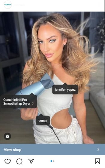 Instagram screenshot of post by Conair showing an example of a creator using the SmoothWrap hair dryer with shoppable tags