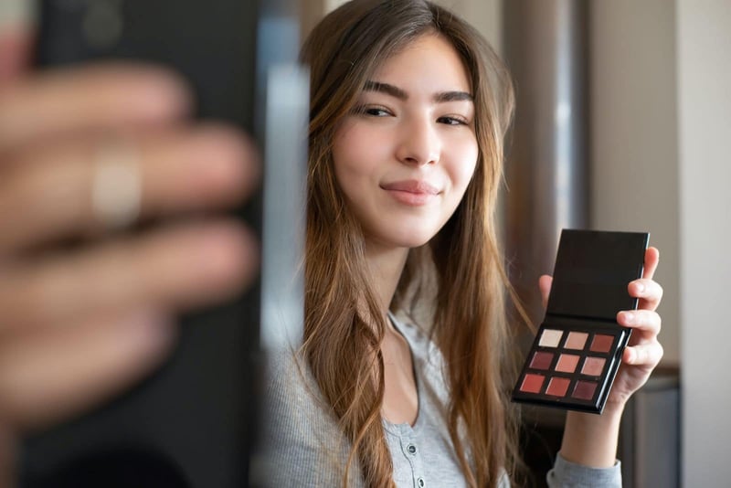 woman taking a picture with a makeup palette