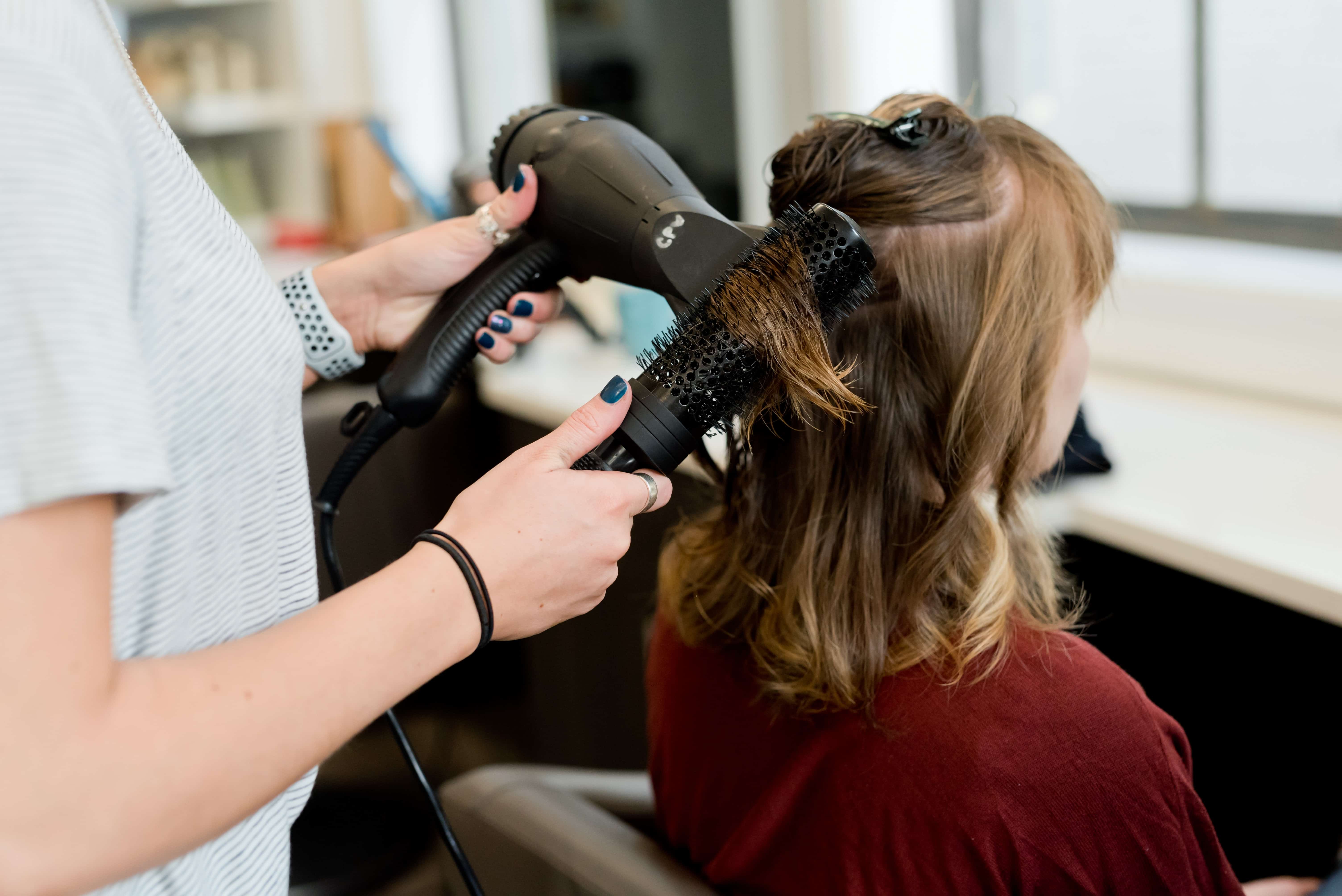 hairstylist giving a client a blow out