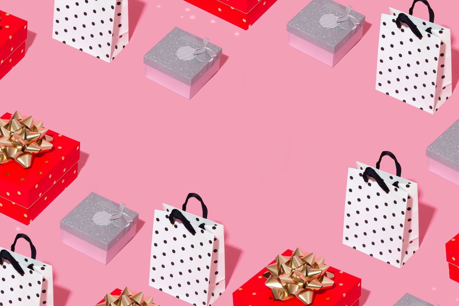 Pink background with assorted gift boxes and bags
