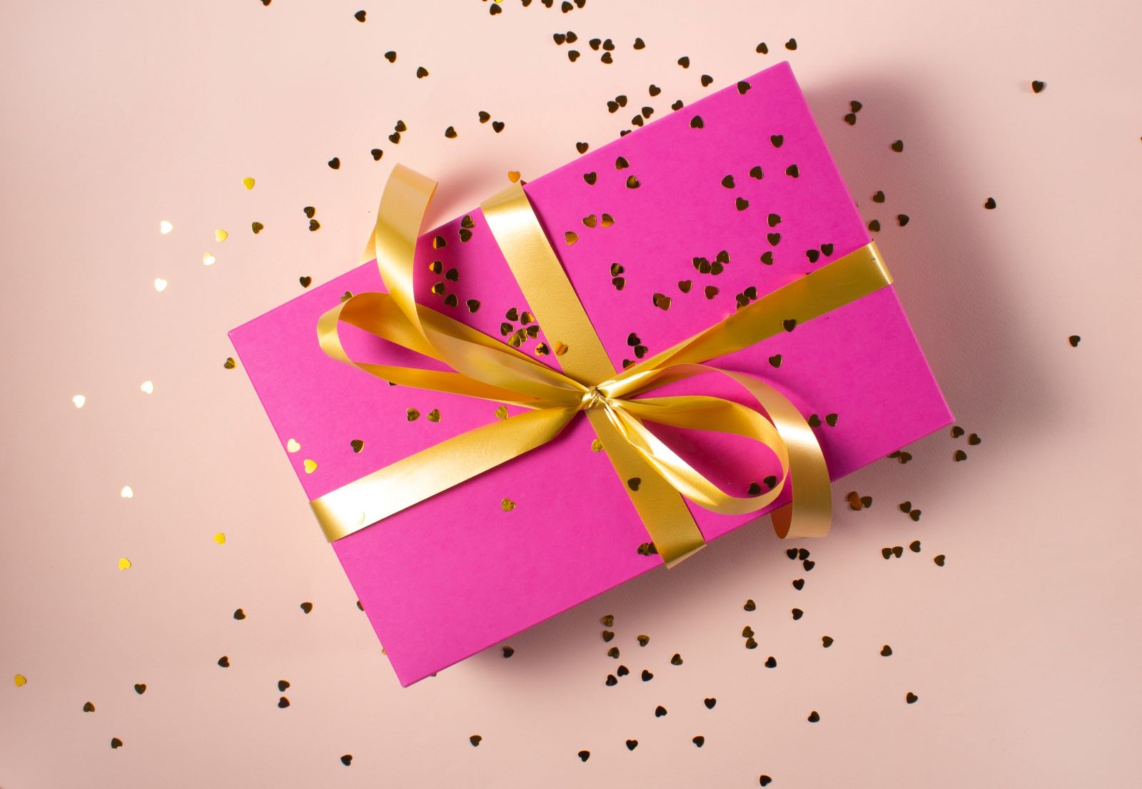 Pink gift box wrapped in gold ribbon