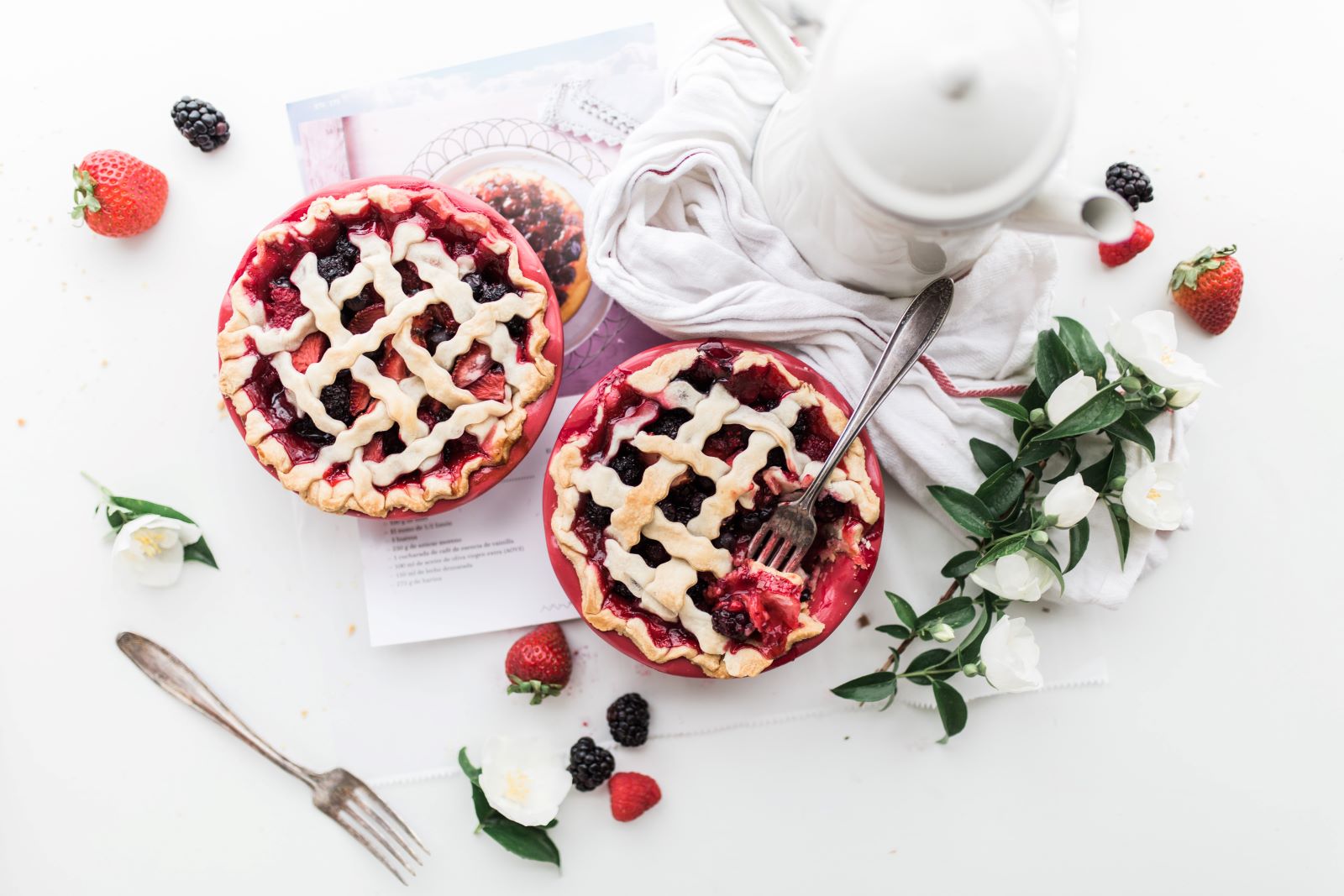 two raspberry pies on top of white table