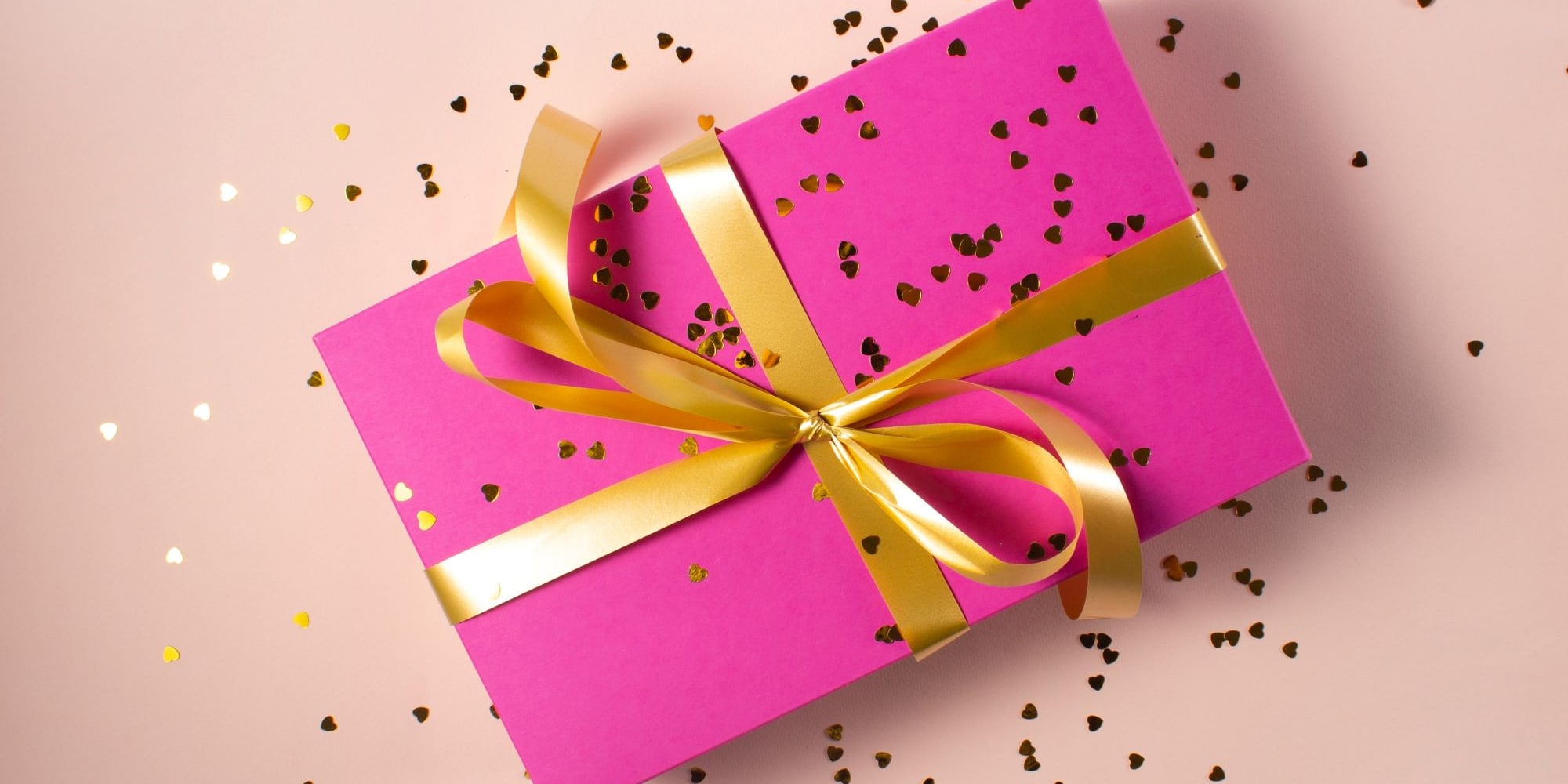 Pink gift box wrapped in gold ribbon